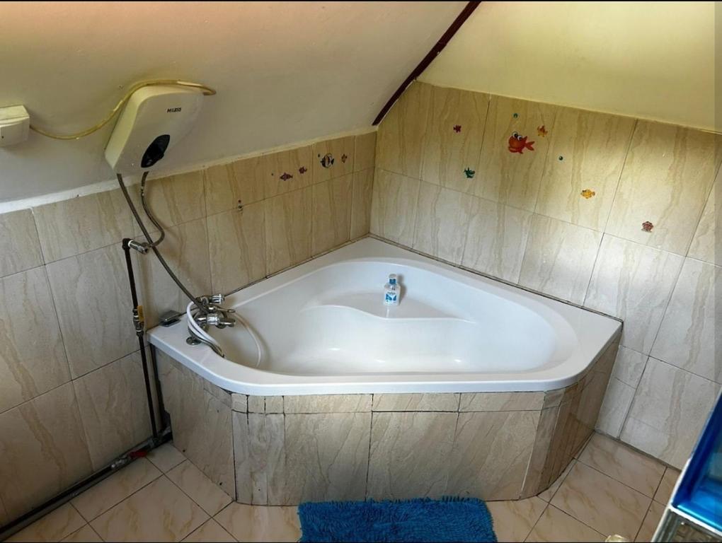 The shared ground-floor bathroom, with a corner bathtub and tiled walls