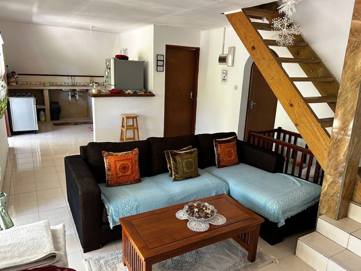 Open living area with seating, staircase and kitchen